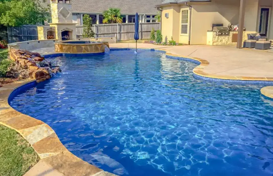 Backyard retreat freeform pool with spa, outdoor fireplace, and kitchen