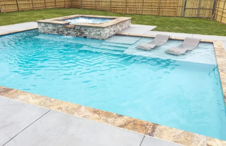 Geometric pool with stacked stone spa, sun shelf, and in-pool loungers